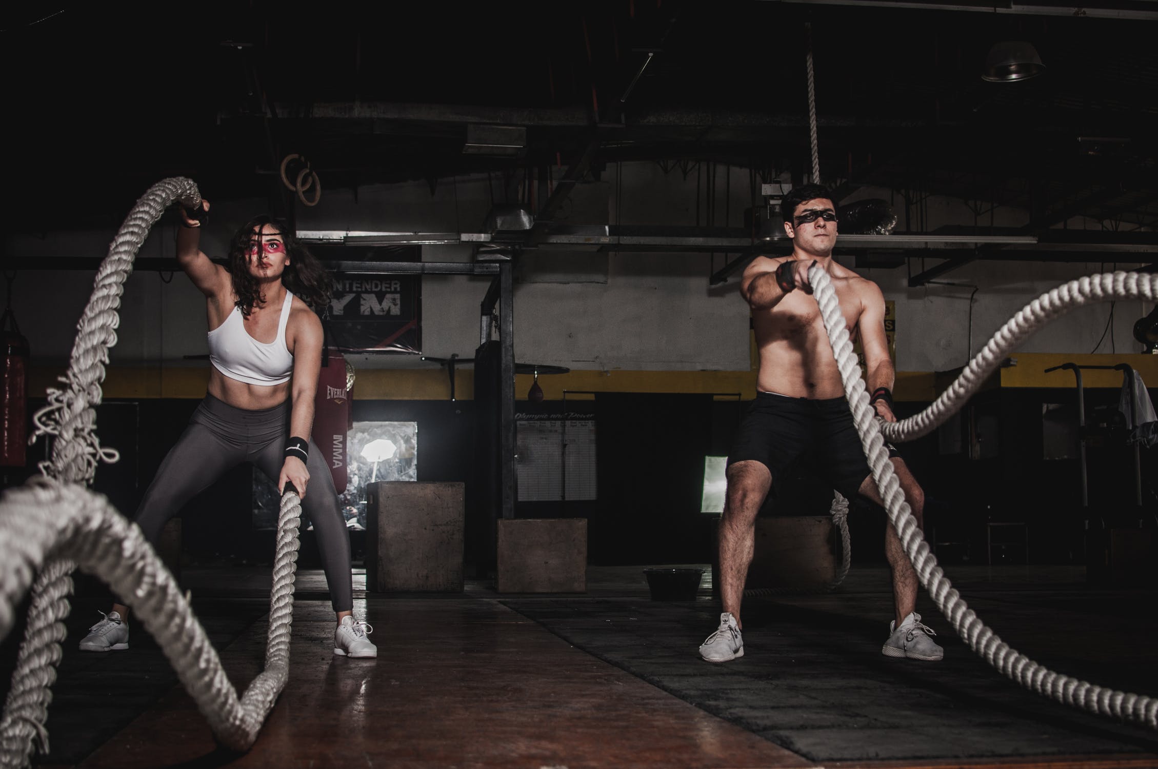 Deux personnes soulevant des cordes dans une salle de CrossFit