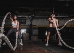 Deux personnes soulevant des cordes dans une salle de CrossFit