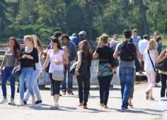 Groupe d'étudiants passant entre pont de bois et restaurant le Lac