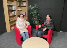 Deux collègues lituaniennes assistes sur des fauteuils rouges.