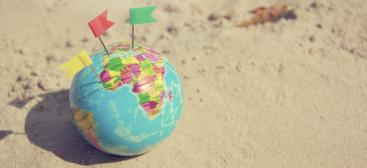 International/ mappemonde sur sable avec drapeaux