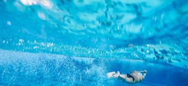 Homme nageant sous l'eau dans une piscine
