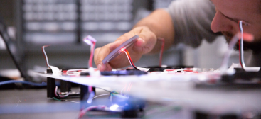 un homme examinant des fils lasers