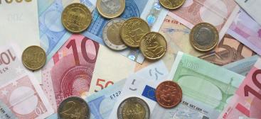 Photo de pièces et billets en euros éparpillés