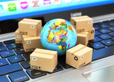 Mappemonde posée sur un clavier d'ordinateur, entourée de petits cartons